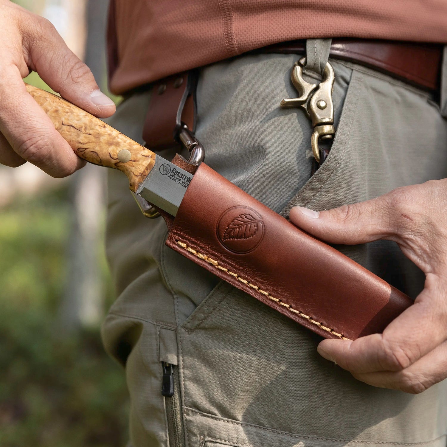 No.8 SFK Scandi Grind with curly birch handle being sheathed on the belt.
