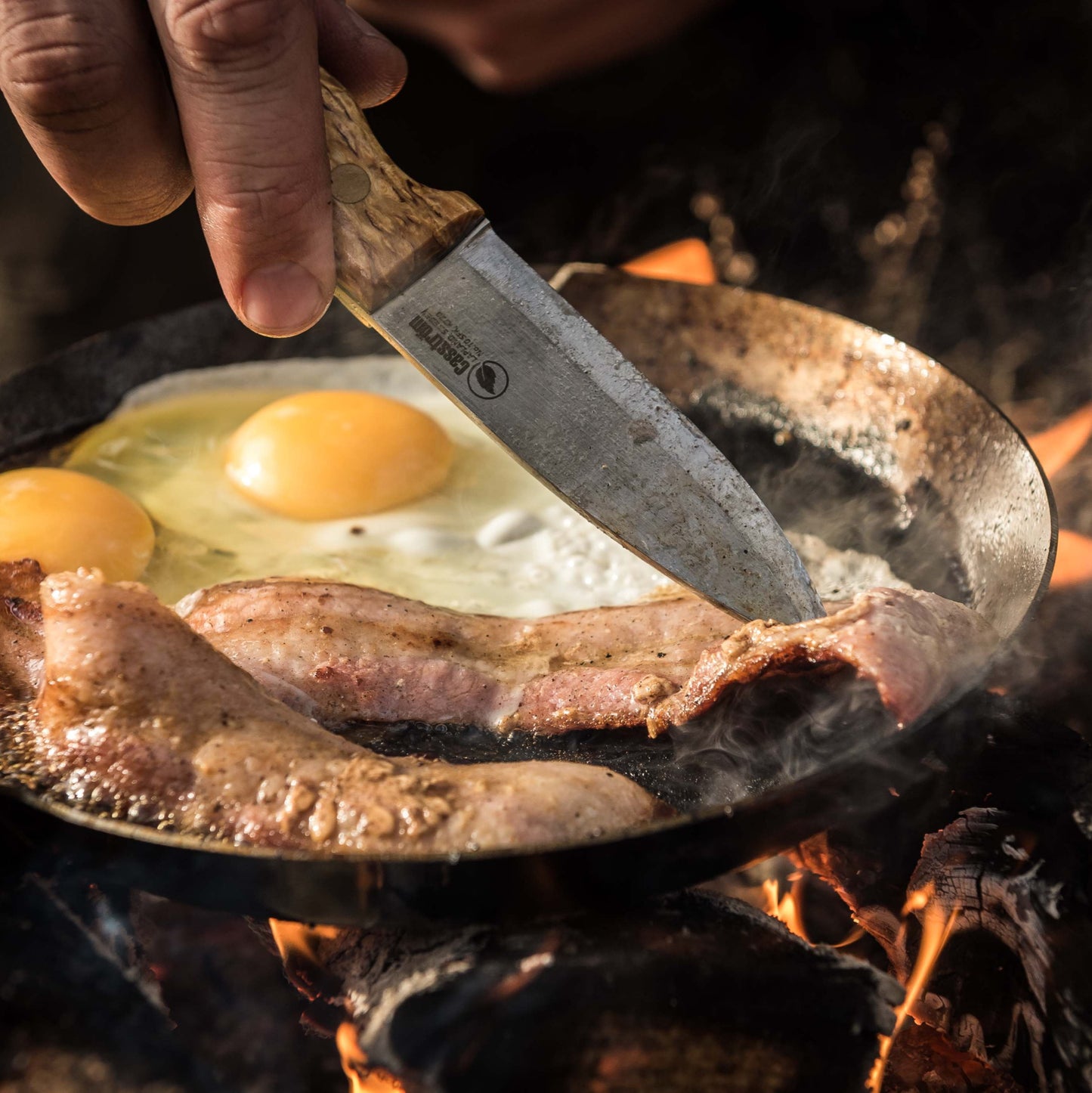 Preparing food over a campfire using the Casström No.10 bushcraft knife