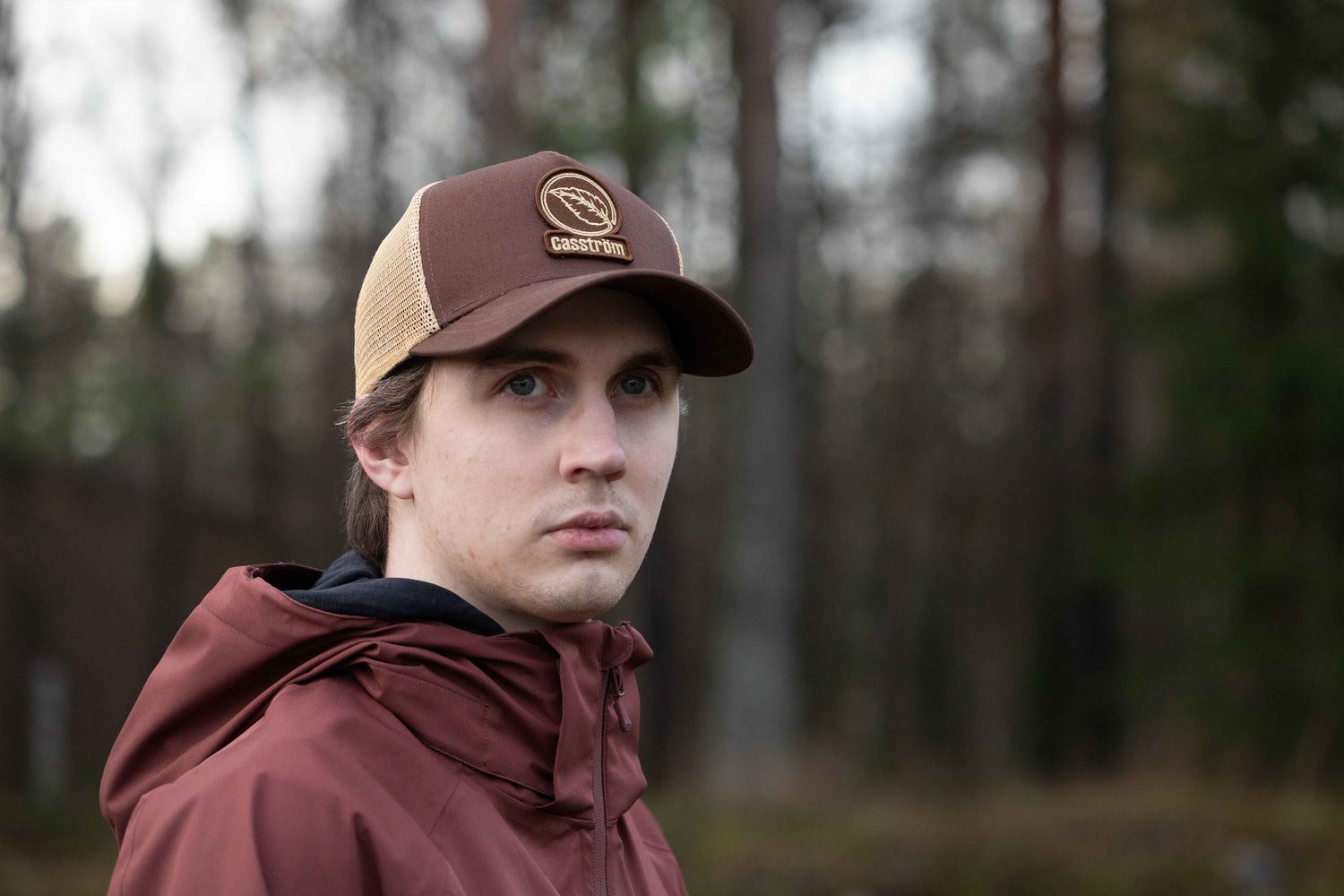Outdoor lifestyle image of a man wearing the Casström Lapland Trucker Cap during a wilderness adventure.