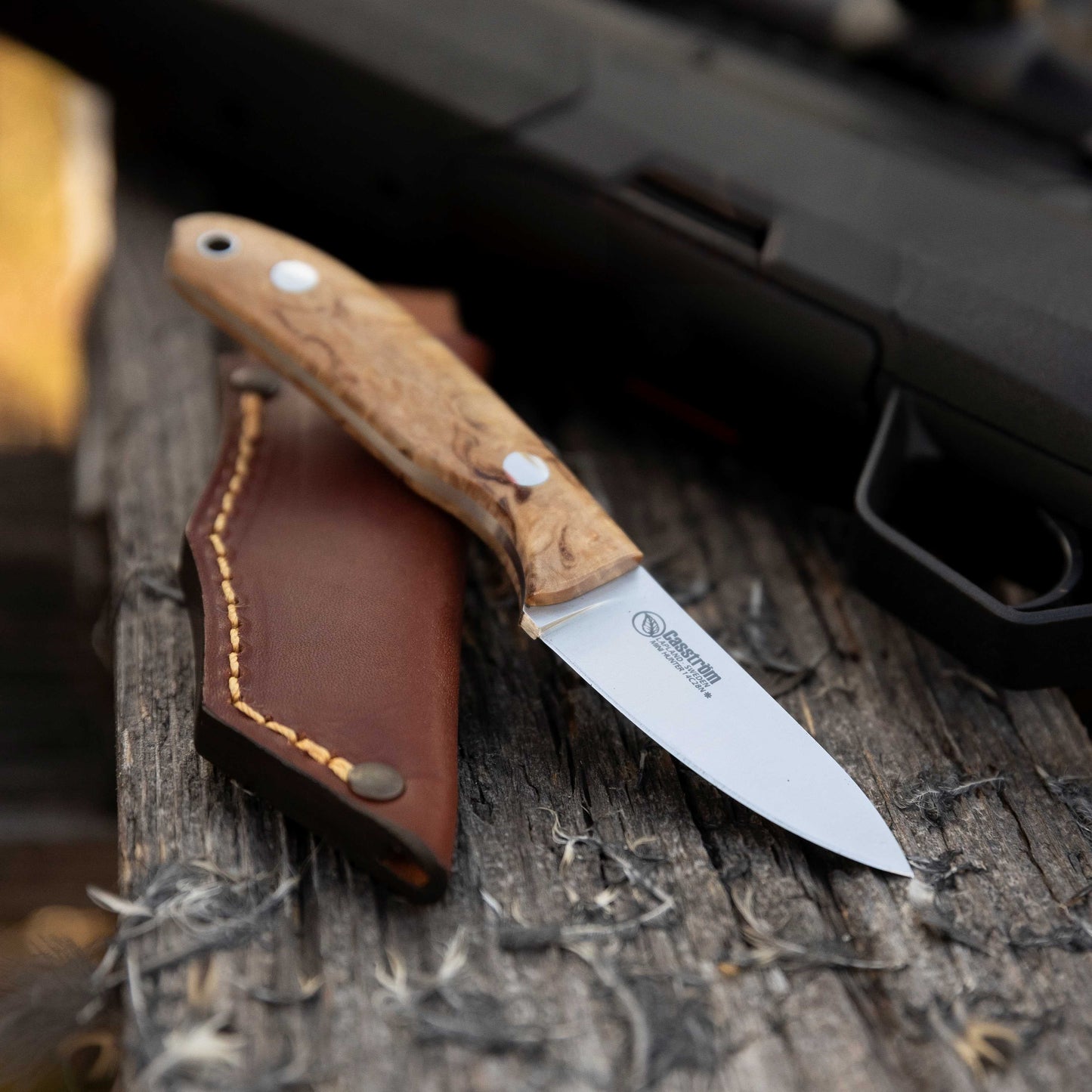 Casström safari small hunting knife next to a hunting rifle.