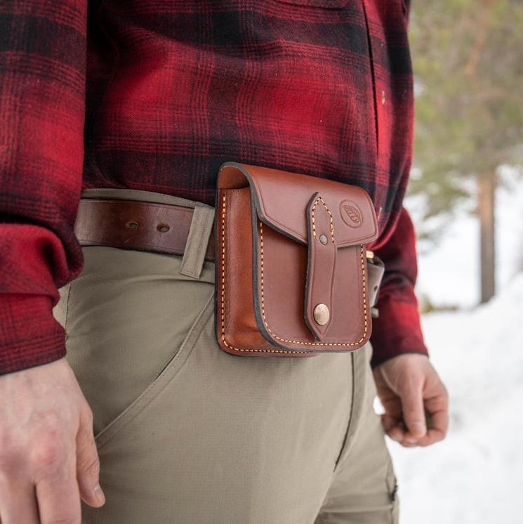 Casström Leather Possible Pouch attached to a Casström leather belt, on a person standing in a forest.