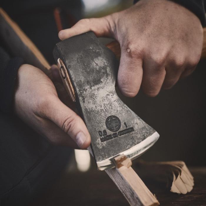 Close up of somebody carving wood with the Agelsjon mini hatchet