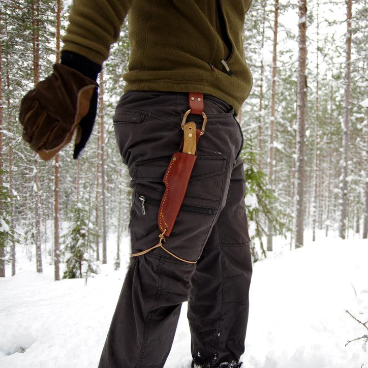 Fixed blade knife sheath hanging from Casström No.3 dangler while walking in winter forest