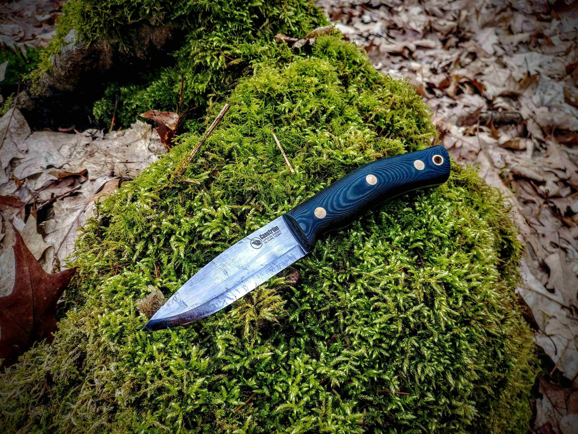 Casstrom No.10 swedish forest knife, in green micarta, lying on a bed of moss