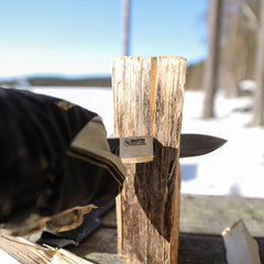 Outdoor lifestyle image of the Casström No.14 SFK splitting firewood with batoning technique in the forest.