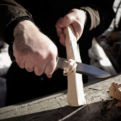 Casström No.14 Swedish Forest Knife carving a feather stick for fire preparation during a bushcraft camp activity.