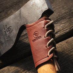 Outdoor lifestyle image of an axe fitted with a Casström leather overstrike guard