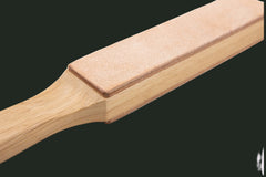 Casström Paddle Strop displayed in a studio product photograph showing dual-surface leather construction for knife maintenance.
