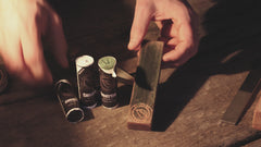 Man applying Casström Swedish Strop Paste to a leather strop before sharpening and polishing a knife blade.