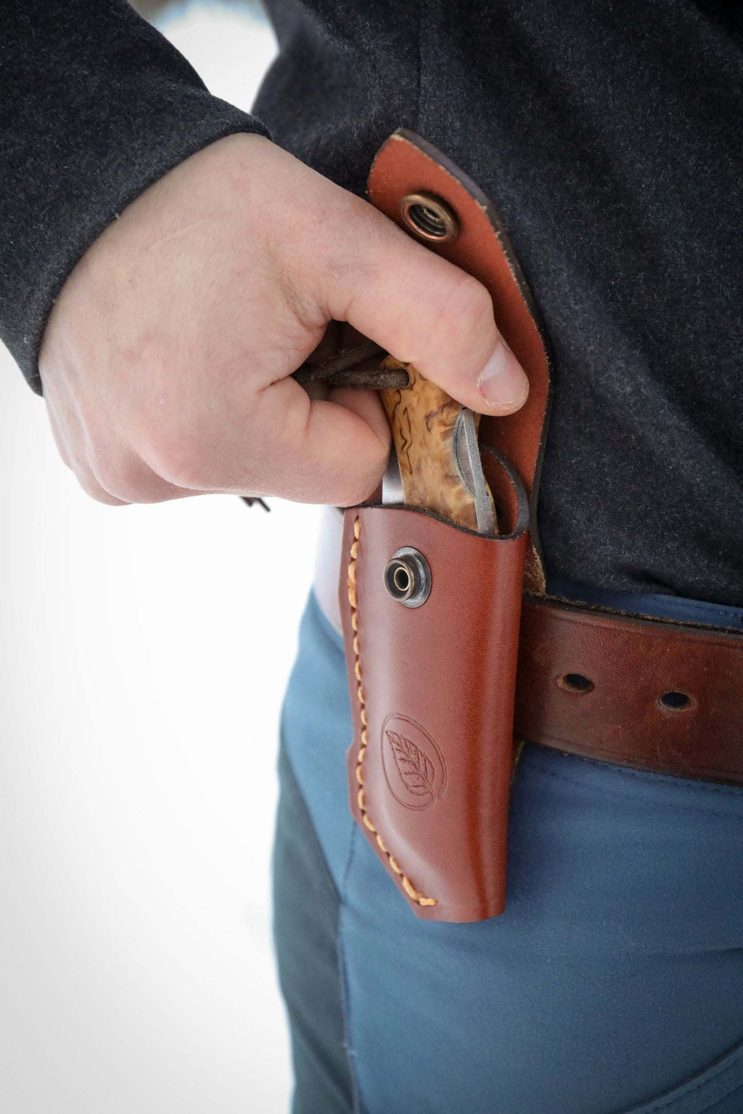 Casström folding knife pouch attached to a belt with a Lock Back folding knife being removed