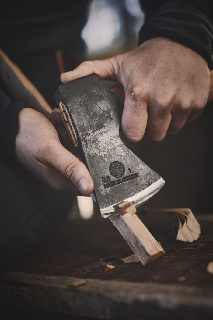 Close up of somebody carving wood with the Agelsjon mini hatchet 