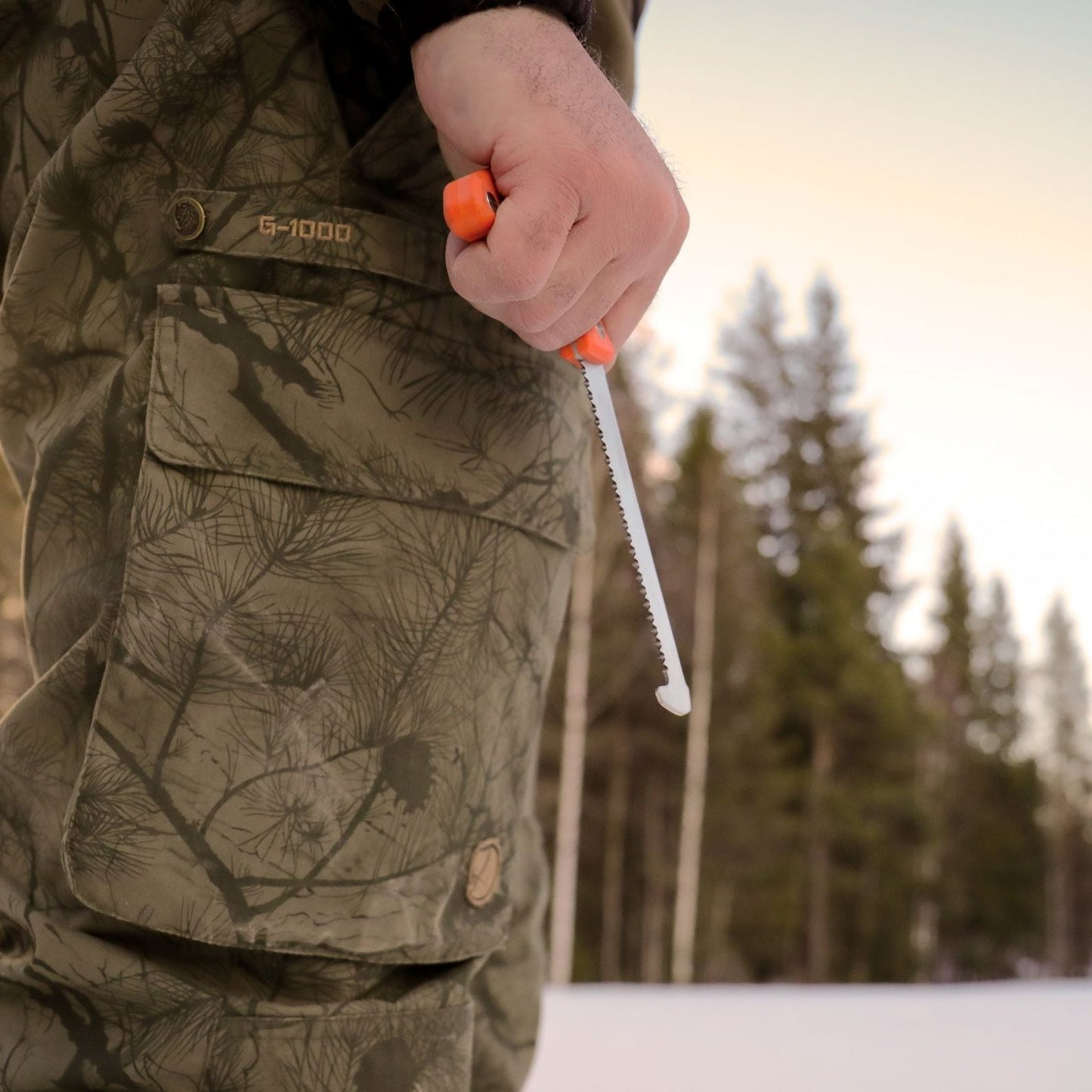 Outdoor shot of a deer stalker holding the Casström No.11 Chest saw