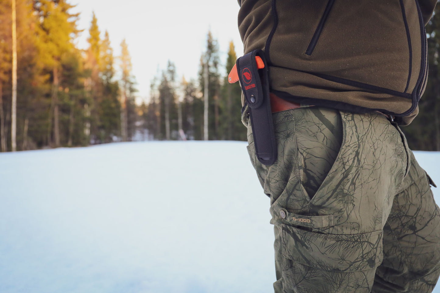 Outdoor shot of a hunter with the Casström No.11 Field Saw in the cordura nylon pouch on his belt.